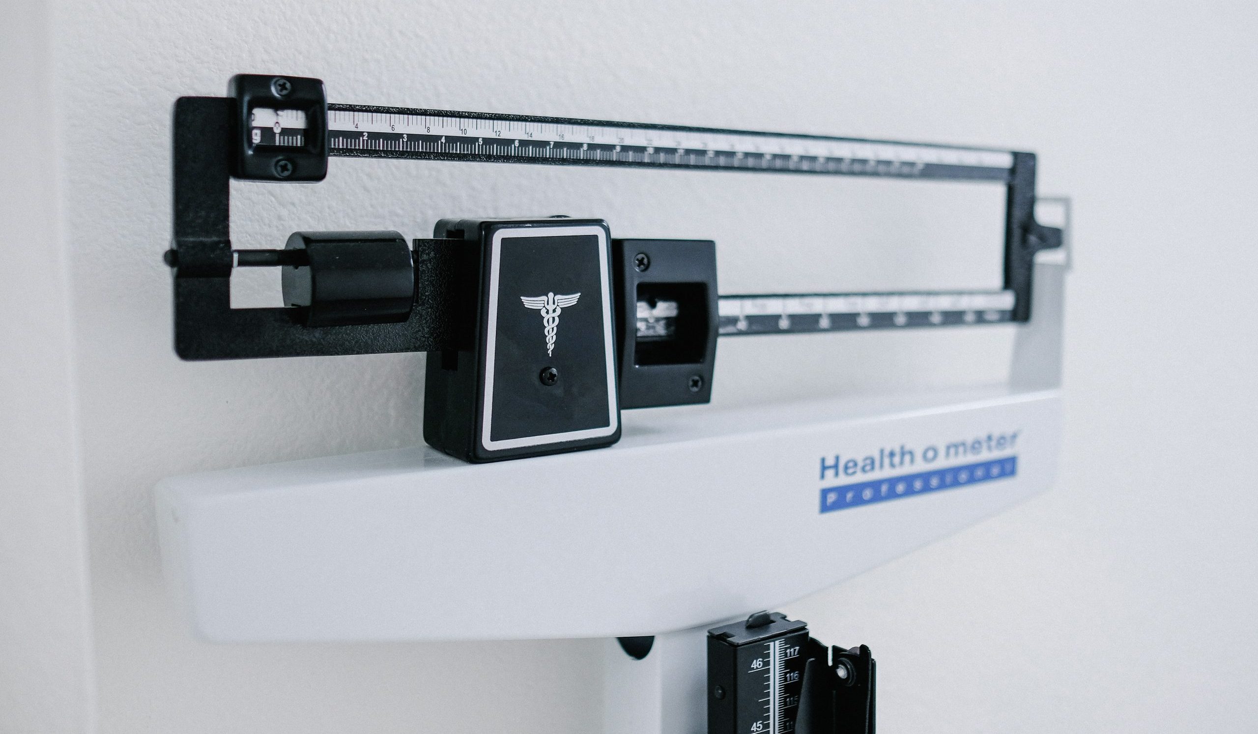The top portion of a medical weight scale as seen in a doctor's office or a weight loss clinic.